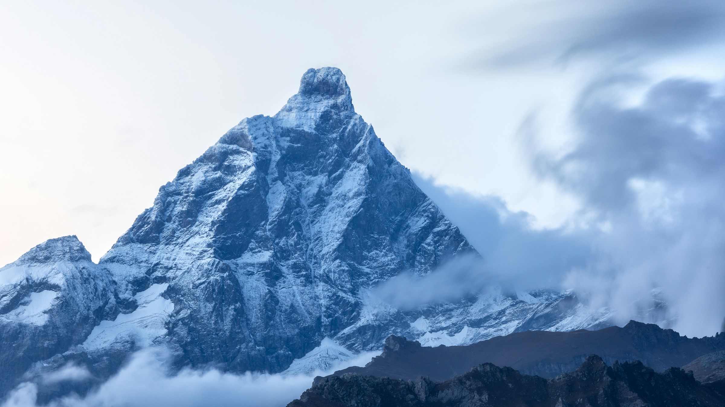 Dramatic mountain peak cutting through clouds